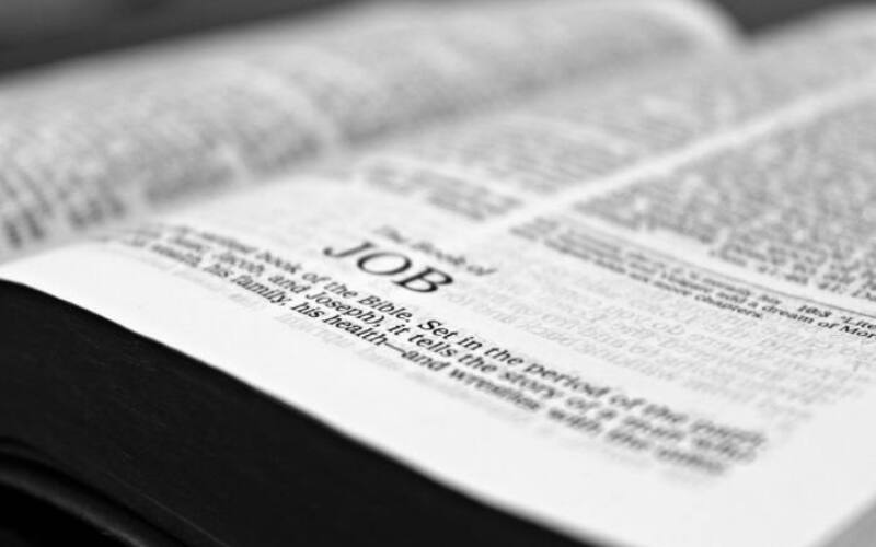 Close-up black and white image focusing on a Bible page with the Book of Job.